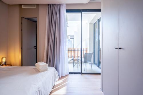 a bedroom with a bed and a balcony with a chair at TWENTY SIX ANFA LUXURY RESIDENCE by Shortstaymaroc -Hyper Centre -Parking in Casablanca