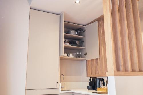 a kitchen with white cabinets and a mirror at TWENTY SIX ANFA LUXURY RESIDENCE by Shortstaymaroc -Hyper Centre -Parking in Casablanca