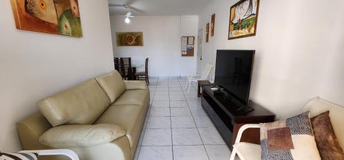 ein Wohnzimmer mit Sofa und Fernseher in der Unterkunft Novo, Iluminado 3 Quartos Piscina Garagem in Ubatuba