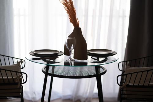 a glass table with a vase and a wine glass at TWENTY SIX ANFA LUXURY RESIDENCE by Shortstaymaroc -Hyper Centre -Parking in Casablanca
