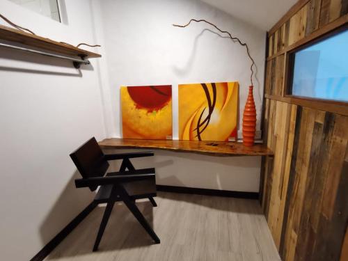 a desk in a room with a chair and a painting at 7 Wooden Lodge Ipoh City in Ipoh