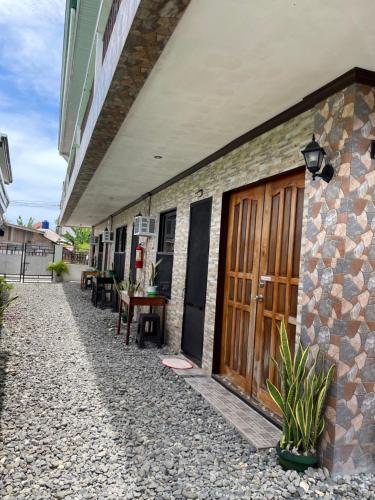 un edificio de piedra con puertas de madera y una mesa en PEPAYEN INN Homestay, en General Luna