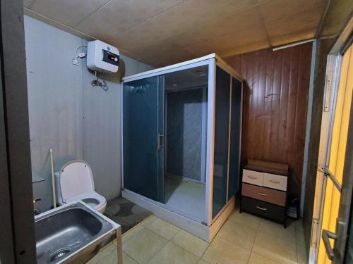 La petite salle de bains est pourvue d'un lavabo et de toilettes. dans l'établissement Melbyls Hills Resort, à Tomohon