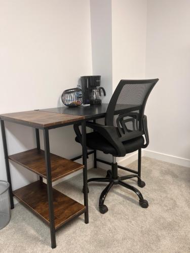a black desk with a black chair and a table at Well furnished Basement Suite-With Private Entrance in Winnipeg