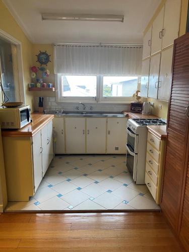 a kitchen with a sink and a stove at Ahoy Family Beach Escape in Portarlington