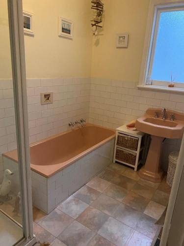 a bathroom with a tub and a sink at Ahoy Family Beach Escape in Portarlington