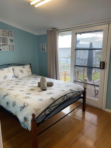 a bedroom with a bed with a view of the ocean at Ahoy Family Beach Escape in Portarlington
