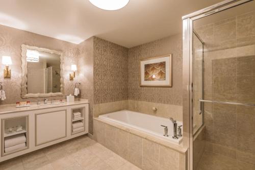 La salle de bains est pourvue d'une baignoire, d'un lavabo et d'une douche. dans l'établissement Attractive Unit by Paris Casino Heart of Strip Las Vegas, à Las Vegas