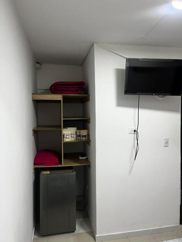 een kamer met een plank en een tv in een kamer bij Hostal Albita 