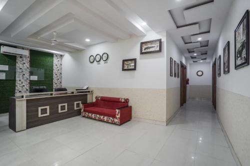 una sala de espera con un sofá rojo en el medio en Hotel Prime Rose en Kurukshetra