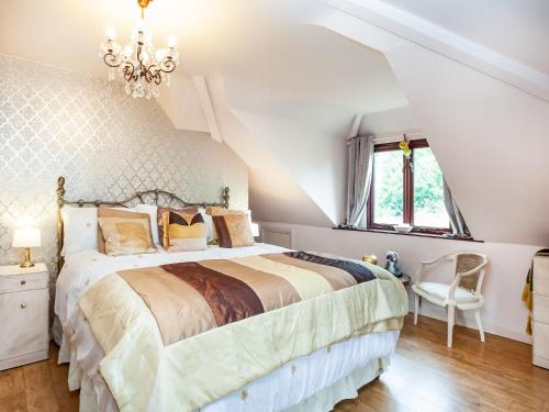 a bedroom with a large bed and a chandelier at Pheasants Haunt in Goodrington