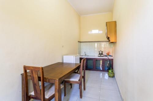 a kitchen with a wooden table and chairs at Jero Harum Homestay in Krambitan