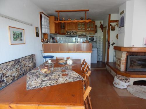 a kitchen with a wooden table and a fireplace at Villa Snejanka in Balchik