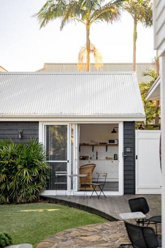 a house with a white door and a patio at Soul of Gerringong Farmhouse in Gerringong
