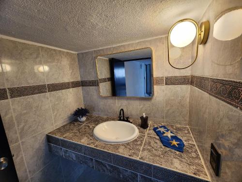 a bathroom with a sink and a mirror at Secretos del Sol Acapulco villas a 5 minutosdel mar in Acapulco