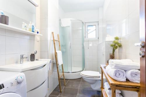 Baño blanco con aseo y lavamanos en Apartments by the sea Pisak, Omis - 21568, en Pisak