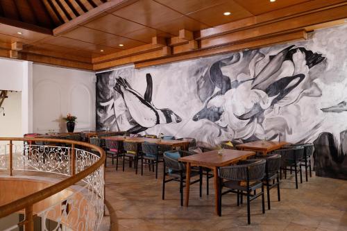 a mural of birds on the wall of a restaurant at Puri Tempo Doeloe Boutique Hotel in Sanur
