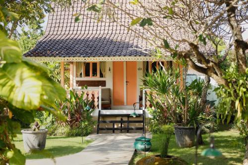 a small house with a bench in a garden at Puri Tempo Doeloe Boutique Hotel in Sanur