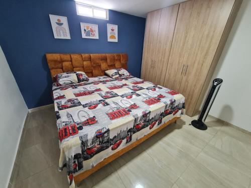 Apartamento Completo Ibague - Parqueadero - Ocobo في إباغويه: غرفة نوم بسرير ولحاف عربة إطفاء