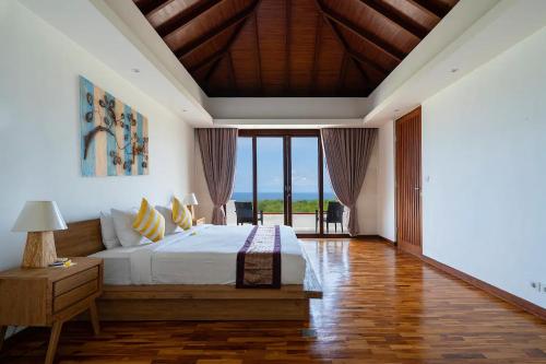 a bedroom with a bed and a large window at Vivo Villas - Villa Vivo in Uluwatu
