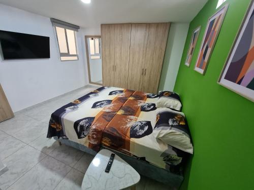 a bedroom with a bed and a green wall at Apartamento Completo Parqueadero - Ibagué - cerezo in Ibagué