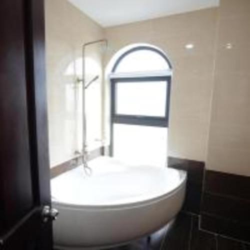 a bathroom with a white sink and an arch window at Quê Tôi Hotel in Soc Trang