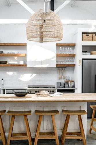 a kitchen with a wooden counter with stools at Soul of Gerringong Cottage in Gerringong