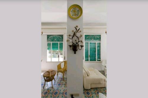 a living room with a clock on a wall at Villa Moschella in Taormina
