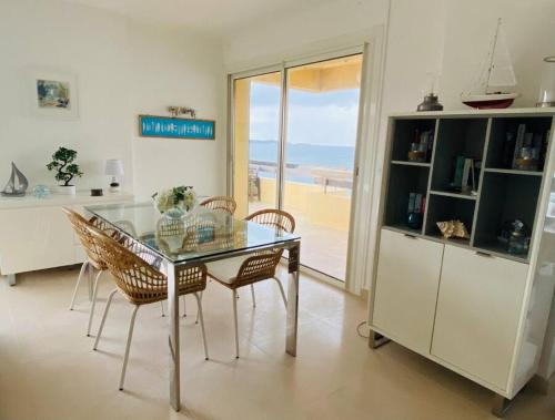 une salle à manger avec une table et des chaises en verre dans l'établissement Penthouse au dessus de la mer, à Six-Fours-les-Plages