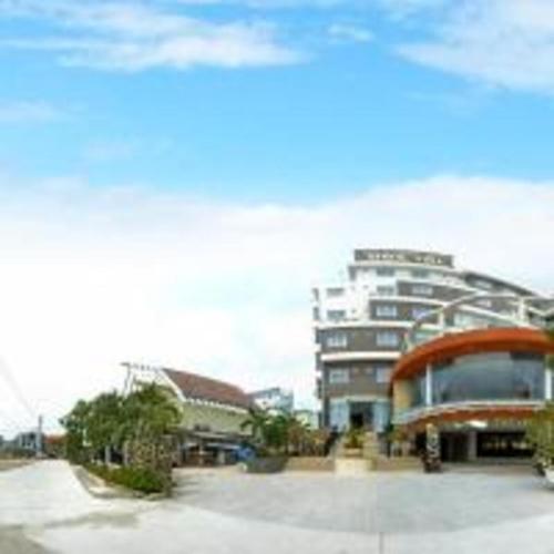 a large building in front of a parking lot at Quê Tôi Hotel in Soc Trang