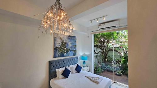 可倫坡的住宿－Lotus Colombo Guesthouse，一间卧室配有一张带吊灯和窗户的床。