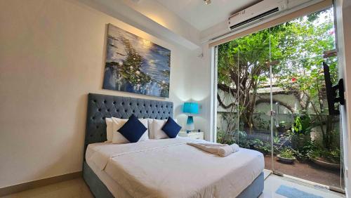 Lotus Colombo Guesthouse في كولومبو: غرفة نوم بسرير ونافذة كبيرة