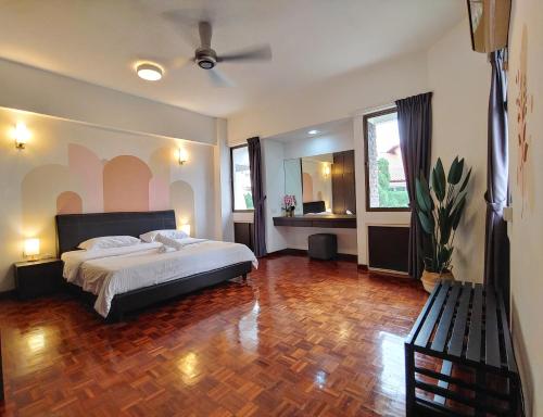 a bedroom with a bed and a wooden floor at GurneyVille in George Town
