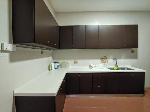 a kitchen with brown cabinets and a sink at GurneyVille in George Town