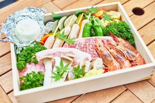 a box filled with different types of food on a wooden table at GLAMPING GATE 奈良 in Nara