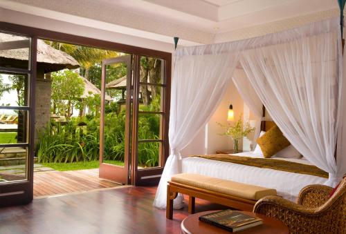 - une chambre avec un lit et une terrasse avec une fenêtre dans l'établissement The Patra Bali Resort & Villas - CHSE Certified, à Kuta