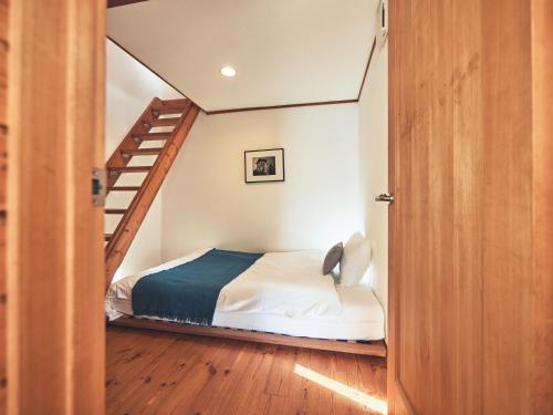 a bedroom with a bed and a spiral staircase at &SUN Penthouse in Yokosuka