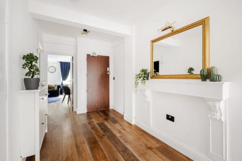 ein Wohnzimmer mit weißen Wänden und einem Wandspiegel in der Unterkunft First Class Living Experience Luxury In Harley St in London