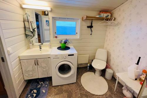 y baño con lavadora y lavamanos. en GuestHouse Seiland, en Skakkebakken