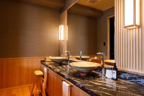 a bathroom with two sinks on a counter at Kyoto Arashiyama Onsen Ryokan Togetsutei in Kyoto