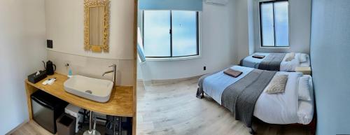 a hotel room with two beds and a sink at CABIN Nozawaonsen in Nozawa Onsen
