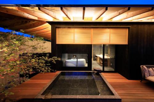 a bathroom with a tub and a sink in a building at Fuji Onsenji Yumedono in Fujikawaguchiko