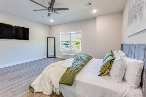 a bedroom with a white bed with a ceiling fan at NEW Classic Cozy Gem *Med/NRG* in Houston