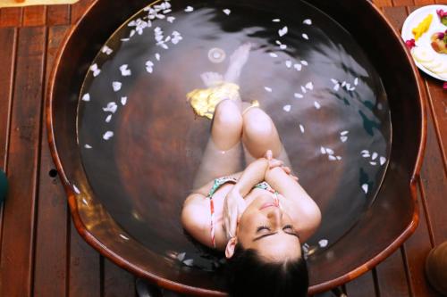 a young girl laying in a bowl of water at Ecoporan Hotel Charme Spa & Eventos in Itacaré