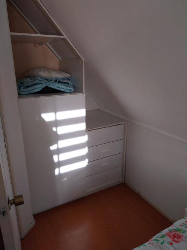 sypialnia z łóżkiem i komodą na poddaszu w obiekcie En la casa bonita w mieście Temuco