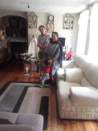 dos hombres y un niño parados en una sala de estar en casa completa en alquiler, en Quito