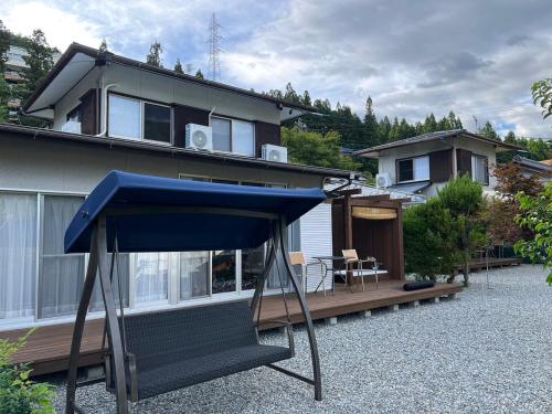 a house with a blue umbrella in front of it at 下呂スプリングスロッジ in Gero
