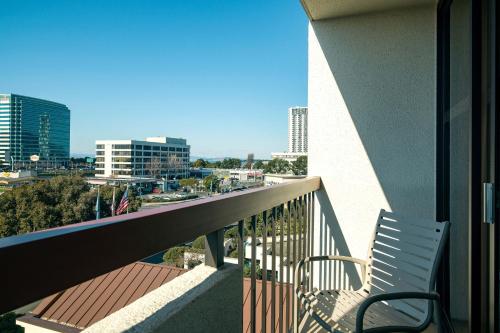 a balcony with two chairs and a view of a city at Four Points by Sheraton - San Francisco Bay Bridge in Emeryville