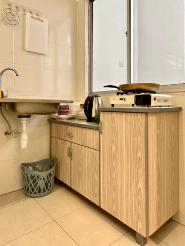 a kitchen with a counter with a sink and a microwave at Casa Ipoh Homestay by Comfort Home in Chemor