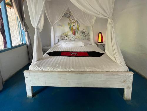 a white bed with a canopy in a bedroom at Blu oceano B&B, Italian restaurant in Nembrala